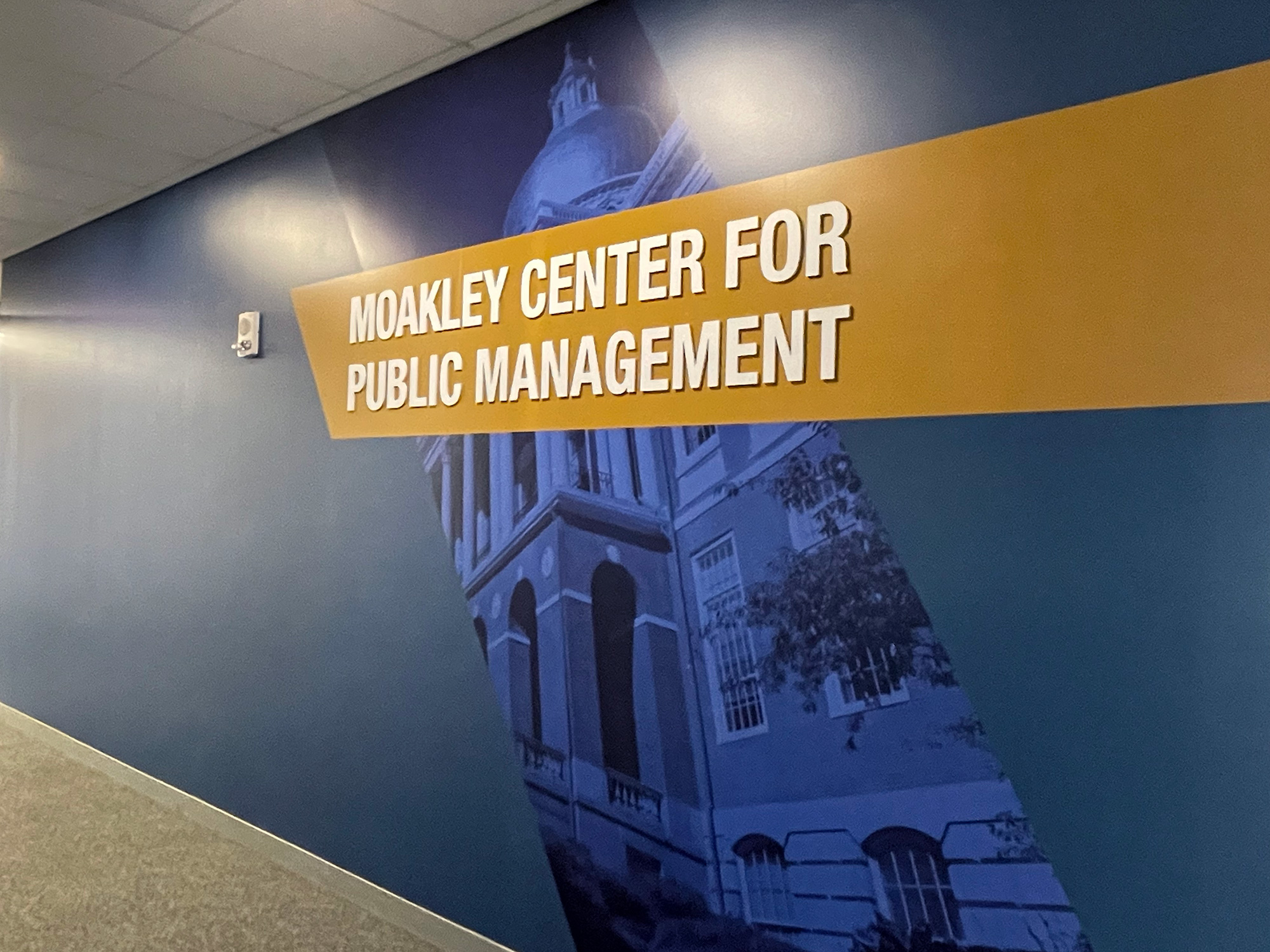 a closeup of the Massachusetts States House and text identifying the Moakley Center for Public Management on the wall