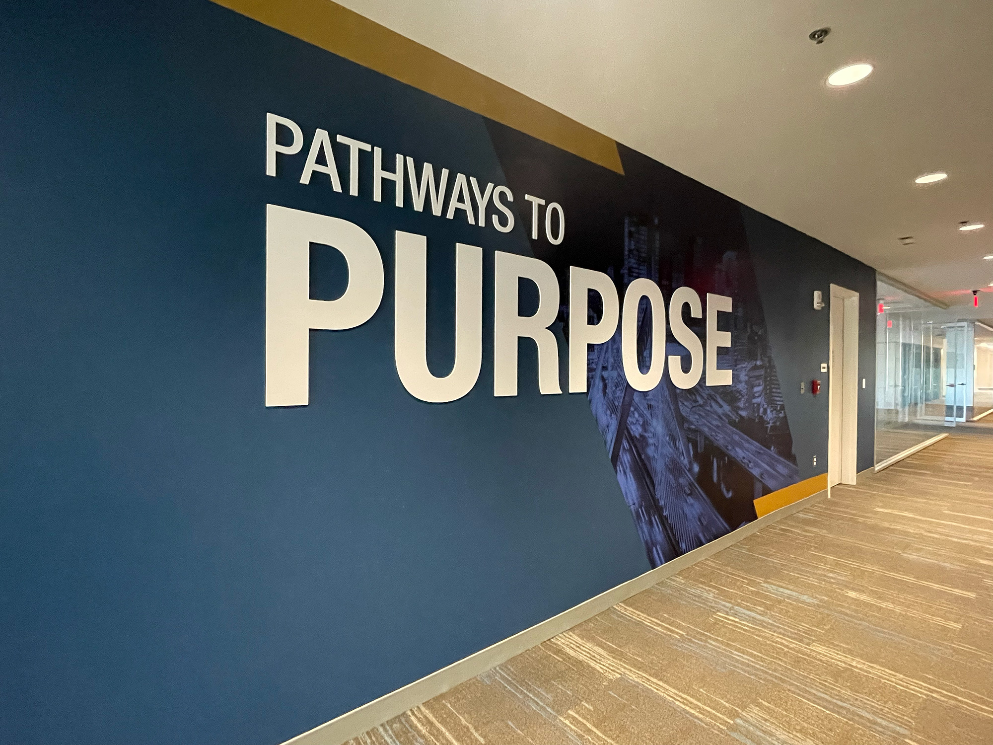 view of the Boston Skyline as entering over the Zakim Bridge with the phrase 'Pathways to Purpose' on the wall
