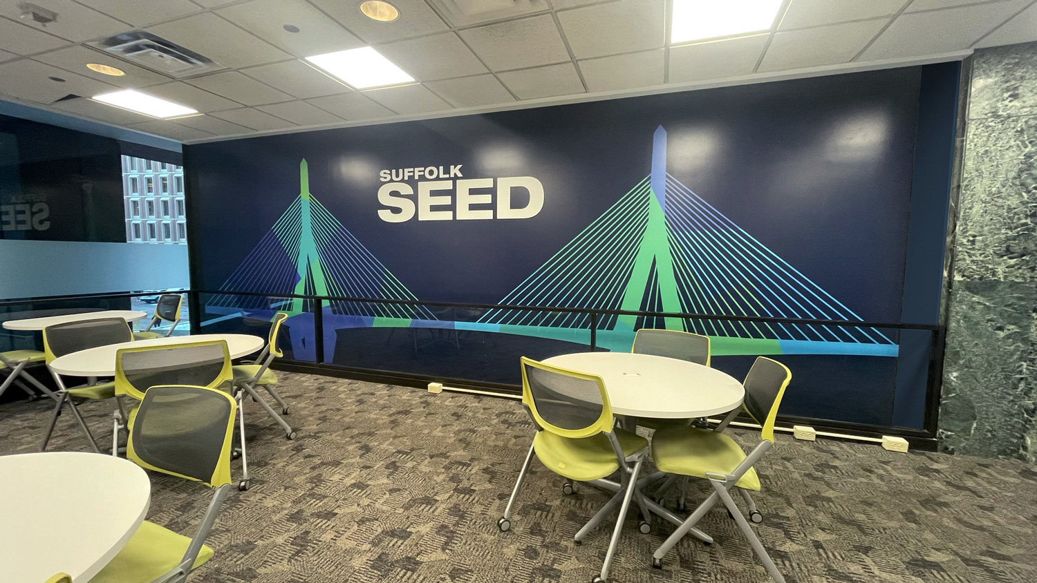 workspace with a large branded wall with the bridge graphic and 'Suffolk SEED' on the wall